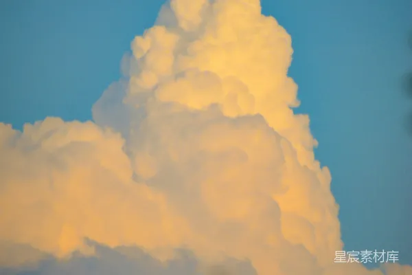 高清摄影 天空中一大片云彩，前景有树木。