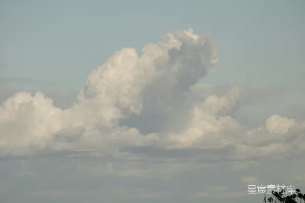 高清摄影 天空中有大片云彩，遮蔽了一些树木。