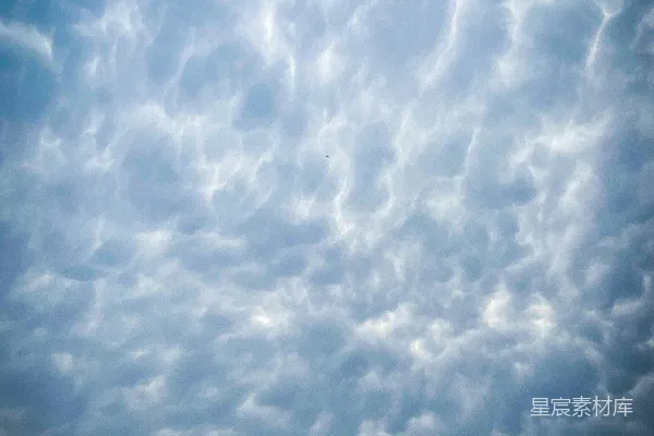 高清摄影 一架飞机在云层间穿过蔚蓝的天空