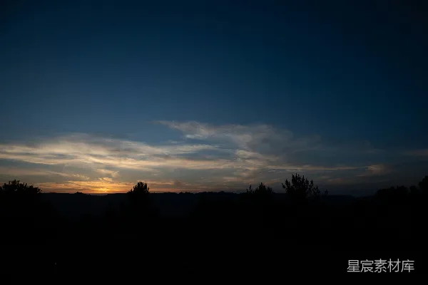 高清摄影 夕阳西下，一片田地环绕着树木。