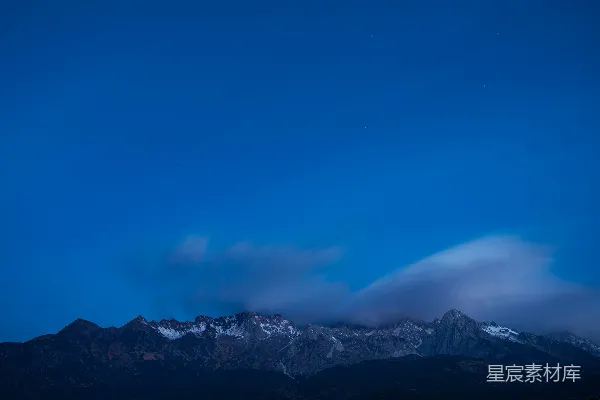 高清摄影 夜空中有云和山峦在背景中。