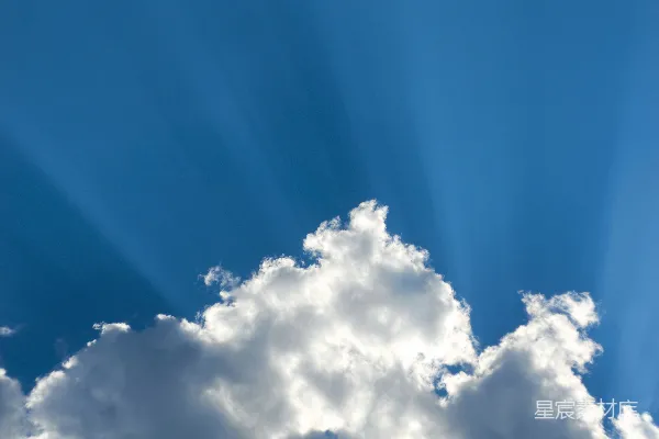 高清摄影 阳光透过一团蓬松的云朵照在蔚蓝的天空中。