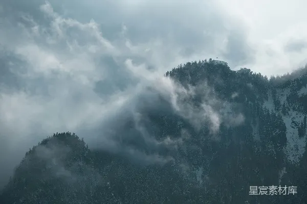 高清摄影 云雾缭绕的山峦和树下阴云密布的天空