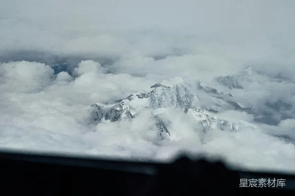 高清摄影 从飞机上看去，雪山之巅在云雾中显现。