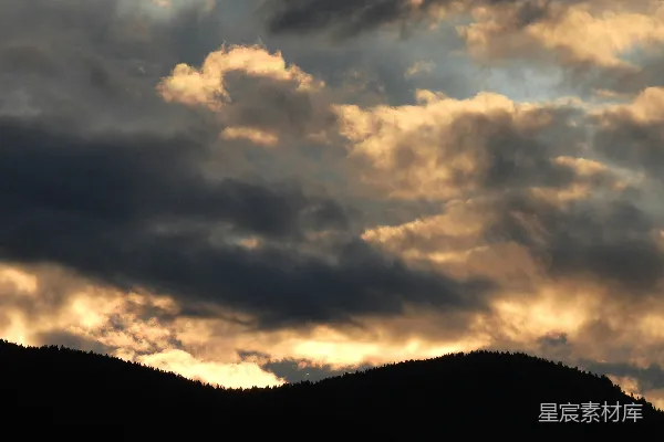 高清摄影 夕阳下壮丽的云层照亮黑暗的山丘。