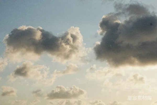 高清摄影 fluffy云漂浮在浅蓝色的天空中。