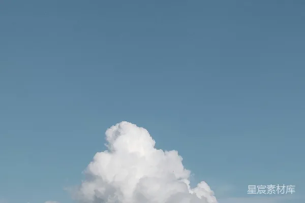 高清摄影 一朵 fluffy 的云衬托着一片清澈的蓝天。