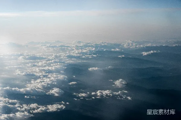 高清摄影 黎明时分，山峦间云雾缭绕的高空俯视景象。