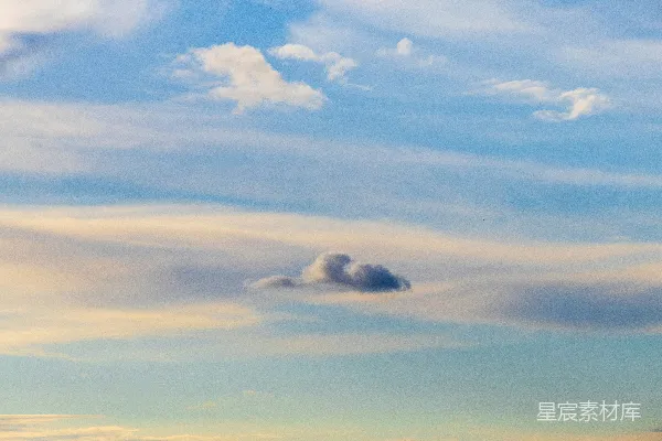 高清摄影 蓝天中有零星的白云，有白色的也有橙色的。