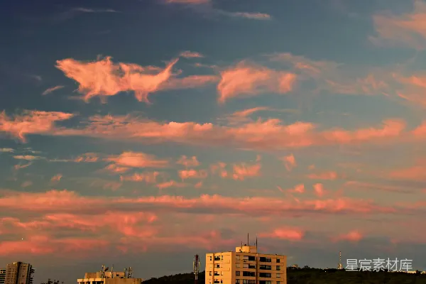 高清摄影 夕阳下，粉色的云朵在蓝天上掠过。