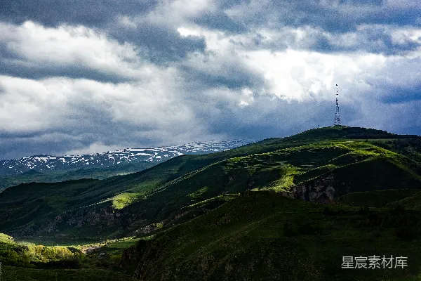 高清摄影 绿 hills 和 雪山 在 晃 动 的 浓重 云 彩 下 。