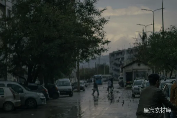 高清摄影 一个男子在一条被雨水浸湿的街道上骑自行车。