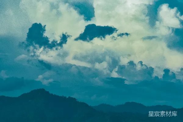高清摄影 一架飞机在云层中飞行，背景是山脉。