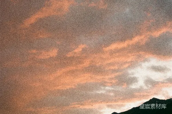 高清摄影 夕阳下粉色的云朵飘过暗山的轮廓影子