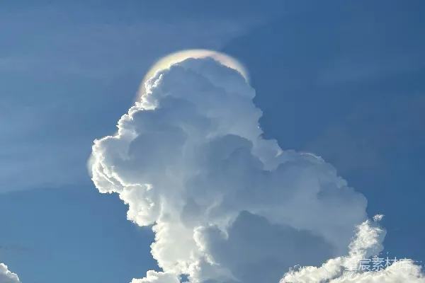 高清摄影 一片巨大的发光云状物悬停在蔚蓝的天空中。
