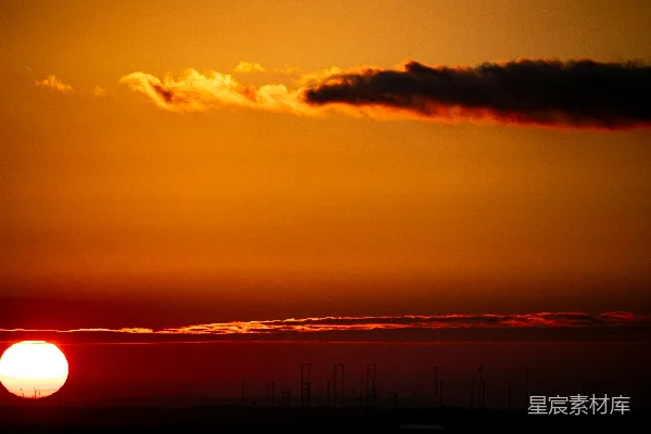 高清摄影 夕阳西下，落日余晖洒在一片水域的天际之上