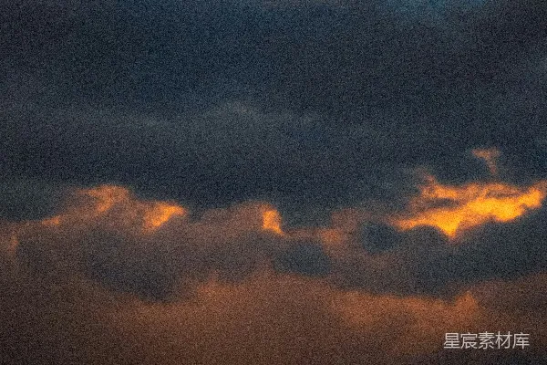 高清摄影 dramatic dark clouds illuminated by golden sunset light.
