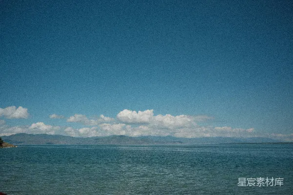 高清摄影 蓝天白云下远处山峦间的深蓝色湖泊。