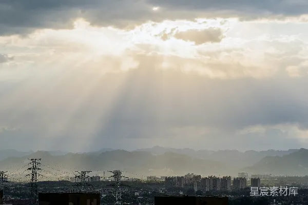 高清摄影 阳光穿透云层照耀在城市和山脉之上。