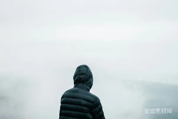 高清摄影 一个穿着黑色夹克的人眺望着一片雾气缭绕的山景。