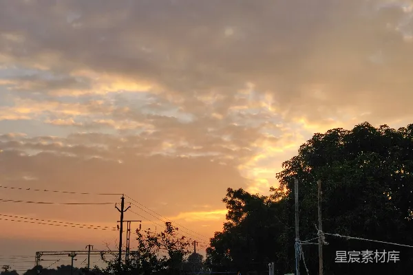 高清摄影 夕阳下的天空，云层覆盖着树木和电线杆