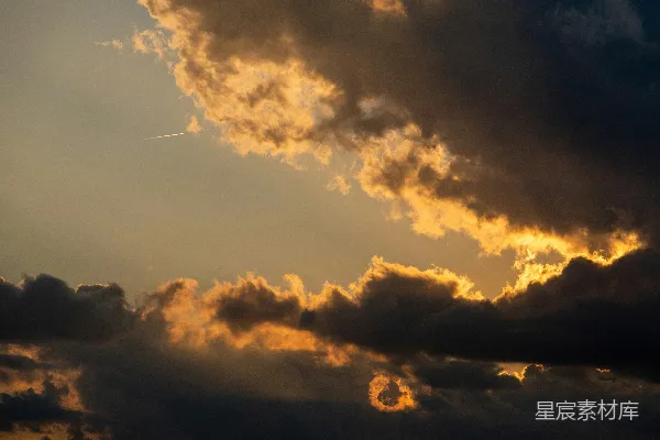 高清摄影 夕阳下的天空中，有戏剧性的深黑色云朵和金色的光线。