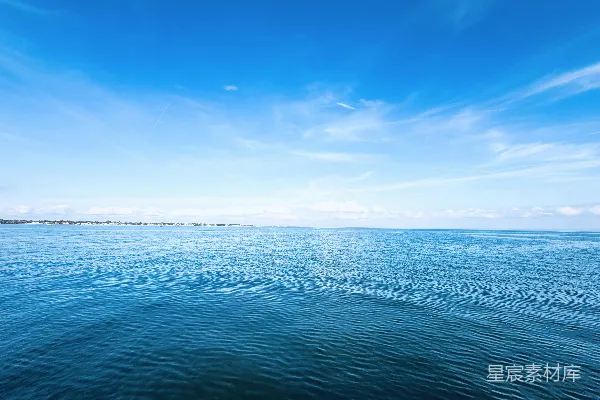 高清摄影 蔚蓝的大海在晴朗的天空下，远处是陆地。