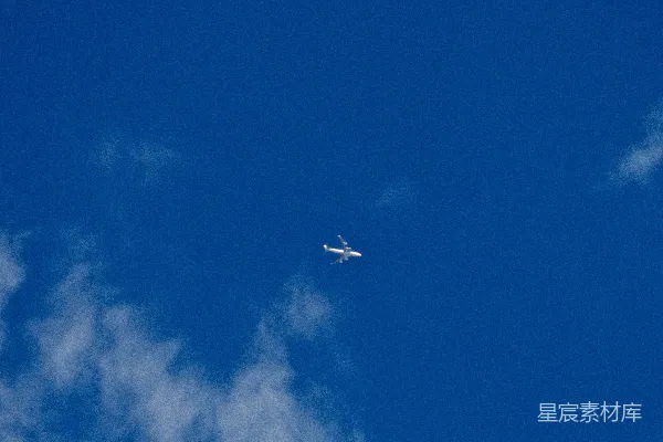 高清摄影 一架小白色飞机在湛蓝的天空中飞行。