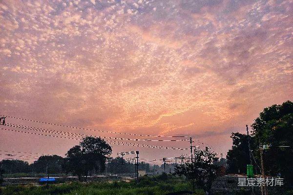 高清摄影 夕阳下，天空中飘浮着粉红和橙色的云朵。