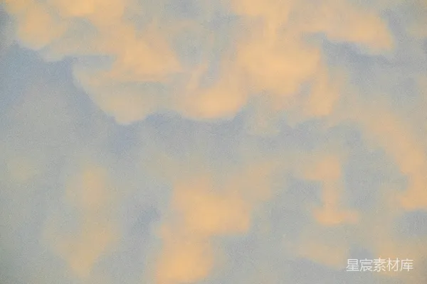 高清摄影 浅橙色的云朵倒映在蔚蓝的天空中。