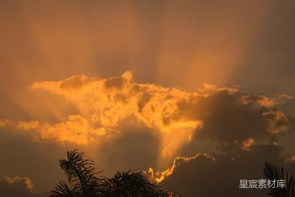 高清摄影 夕阳下，阳光穿过壮丽的橙色云层。