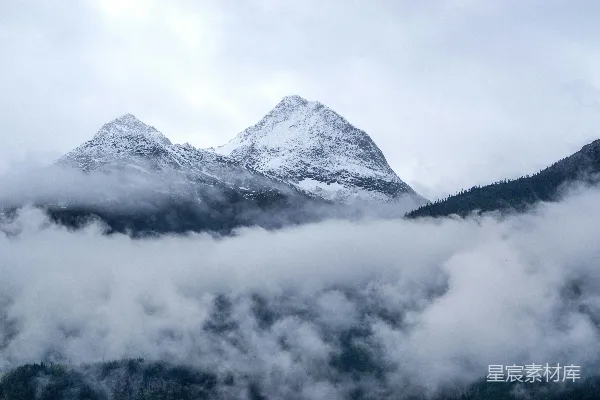 高清摄影 白天雪覆盖的山下云遮雾绕