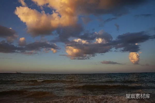 高清摄影 夕阳西下，海面上有一艘船在远处。