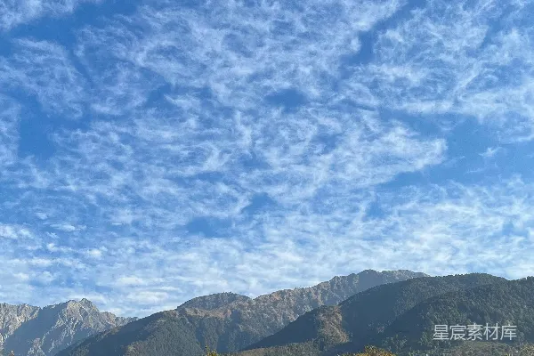 高清摄影 坐落在灰蒙蒙天空下的山峦间的房屋