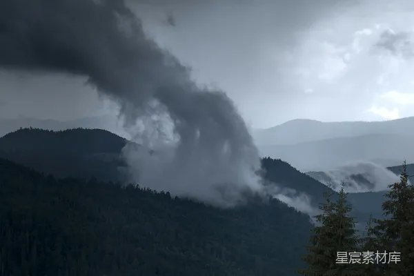 高清摄影 一栋冒烟的建筑物和山峰在背景中