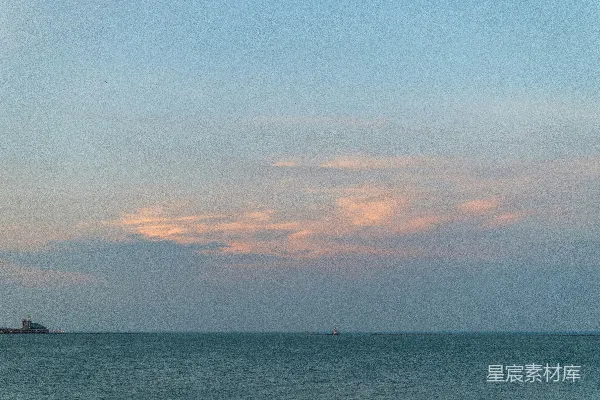 高清摄影 夕阳下的平静海洋上飘着柔和的云彩