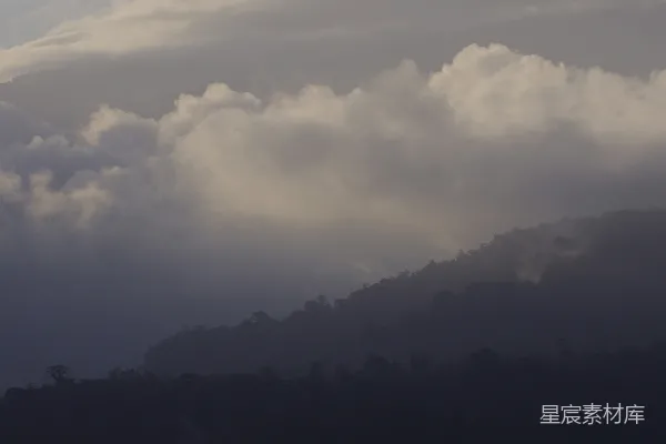 高清摄影 一架飞机穿过云层背景是山峰。