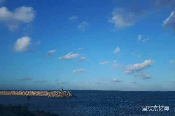 高清摄影 人们站在海滩岸边，在蓝天下白天站立。