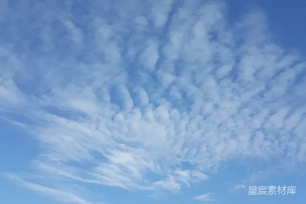 高清摄影 一群人在云层覆盖的蓝色天空下站在海滩上