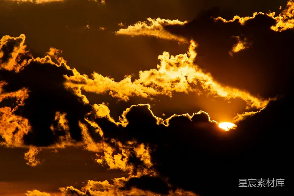 高清摄影 炽热的夕阳透过戏剧性的黑暗云层闪耀。