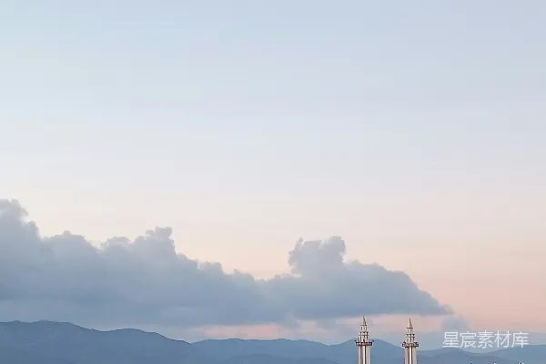 高清摄影 一架飞机在城市的背景中飞过，山峦在远方。