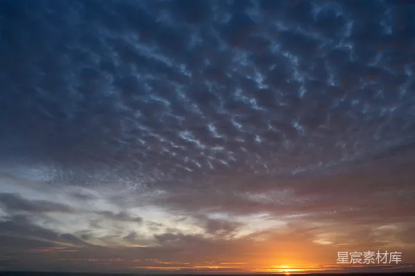 高清摄影 黄昏时分，夕阳映照着一片阴云密布的天空。