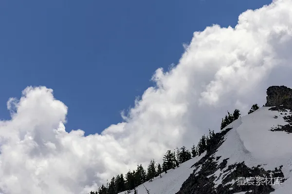 高清摄影 覆盖着白雪的山峦在半阴天的背景下