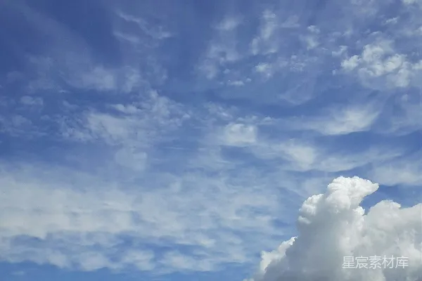 高清摄影 一座城市在天空中矗立着高大建筑物的景象，背景是阴云笼罩下的蔚蓝天空。