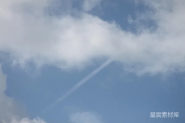 高清摄影 一架飞机在一片云层中的蔚蓝天空中飞行