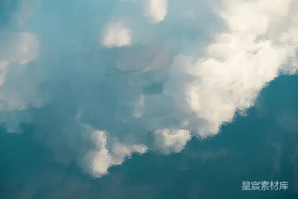高清摄影 一架飞机在一片云层中的蓝色天空中飞行
