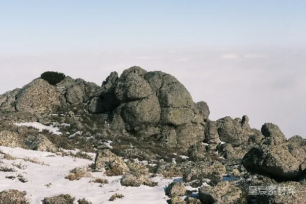 高清摄影 山顶上站着一个人，脚下覆盖着白雪。