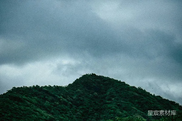高清摄影 灰色云层下的绿山