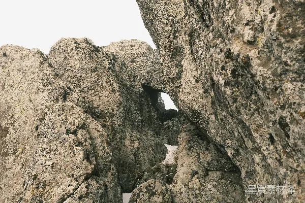 高清摄影 一个攀岩者站在天空背景的岩石峭壁上