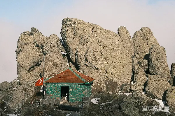 高清摄影 一座小绿色建筑坐落在山顶上。